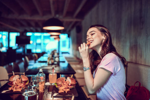 kobieta korzystających burger kolacja w restauracji - sandwich plate food french fries zdjęcia i obrazy z banku zdjęć