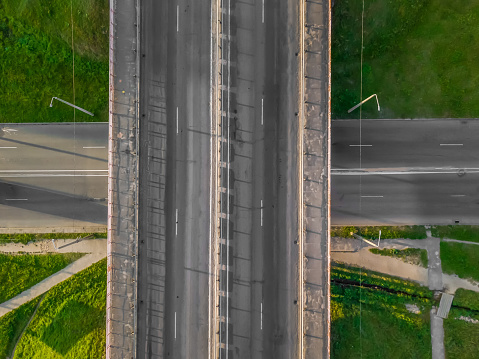 Bridge over a road without cars, top-down view from a drone. Urban infrastructure.
