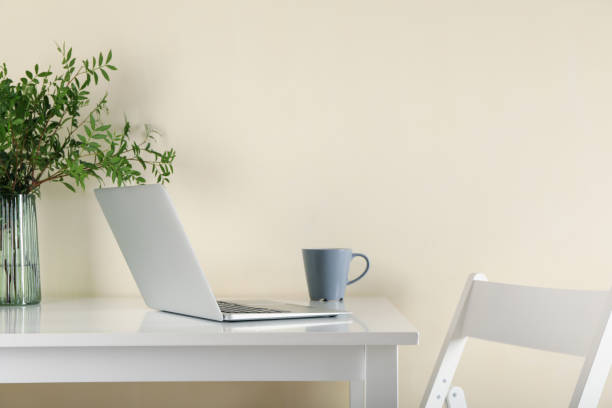 istock Laptop, vase with plant and coffee on white table 1277529372