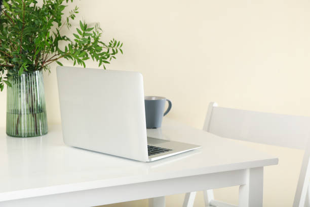 istock Laptop, vase with plant and coffee on white table 1277530139