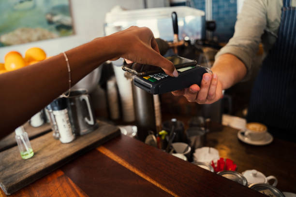 istock Woman using snap scan on cellular device to purchase coffee from funky cafe 1277531280