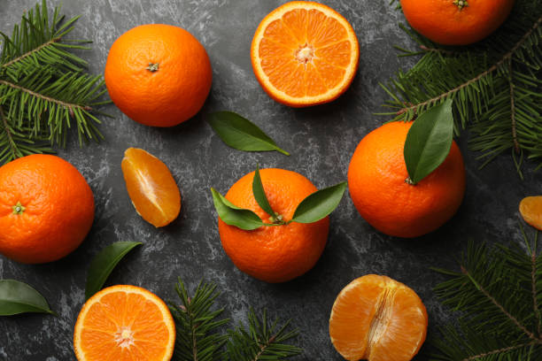 istock Mandarins and pine branches on gray smoky background 1277531994
