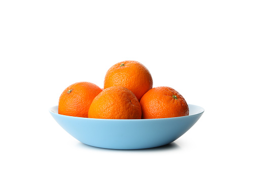 plate of fresh tangerines, oranges, mandarins, or clementines with leaves on the table. still life. close up.