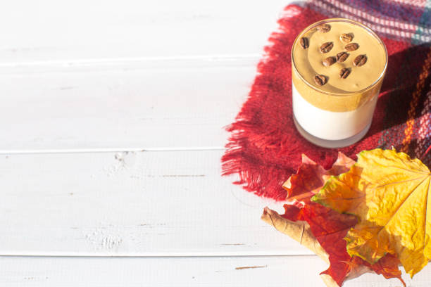 istock Traditional Korean drink, Dalgona coffee in a glass with coffee beans on a white boards background. Autumn breakfast. 1277533595