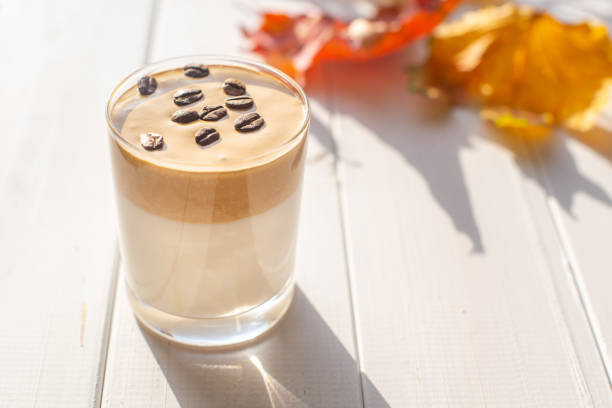 istock Traditional Korean caffeinated milk drink, Dalgona coffee in a glass with coffee beans on a white board background 1277533648