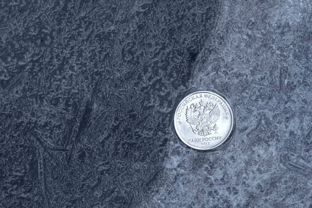 istock Russian ruble coin on thin ice, on the edge of thick and thin ice 1277535157
