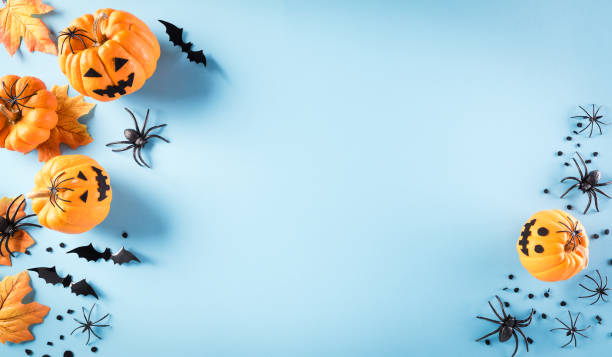 istock Halloween decorations made from pumpkin, paper bats and black spider on pastel blue background. Flat lay, top view with copy space for text. 1277535313