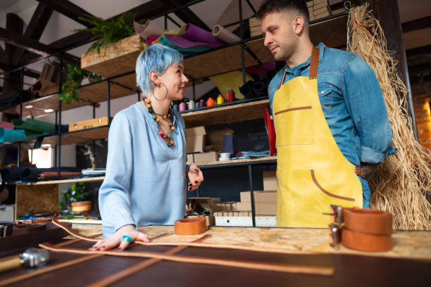 istock Female designer talking with a craftsman about the belt design at the workshop 1277536504