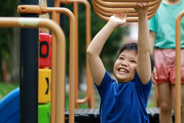 istock Boy swinging on monkey bars in park 1277538303