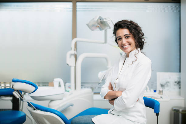 portrait of a caucasian female dentist in her office - dentists chair fotos imagens e fotografias de stock