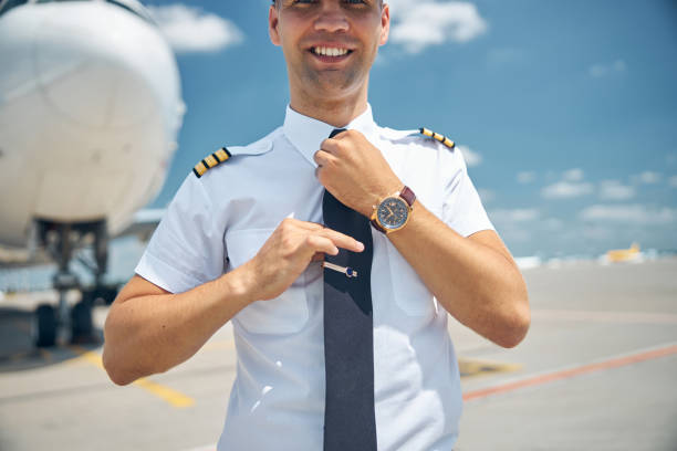 istock Handsome pilot in command adjusting his tie at airport 1277540625