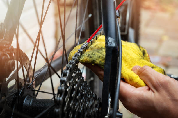 manutenzione e riparazione della bicicletta - pulizia e oliatura della catena di mountain bike e dell'attrezzatura con spray all'olio - chain bicycle chain gear equipment foto e immagini stock