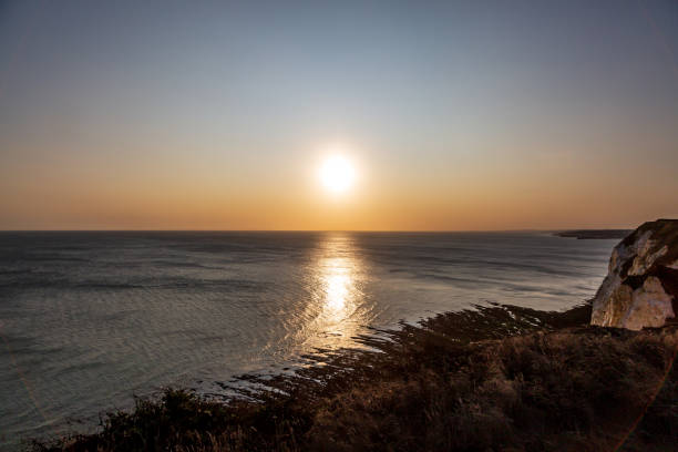 The sun setting over the ocean viewed from the cliffs on the Sussex coast