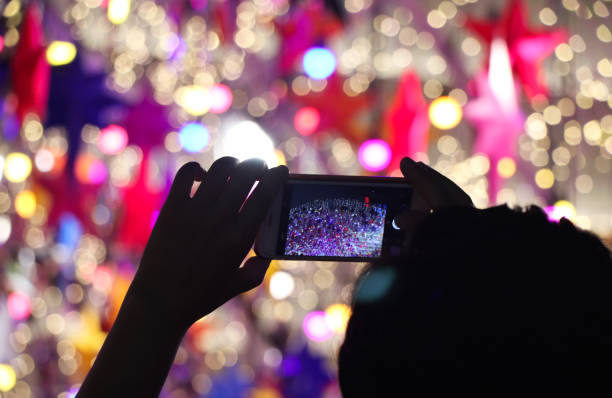 istock Hands holding smartphone for taking night light blurred background colorful electrical celebrate decoration New Year Festival 1277543778