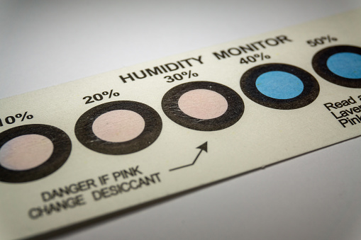 Close-up of humidity indicator cards from electronics manufacturing industry with blue indicator dots, indicating moisture with pink color