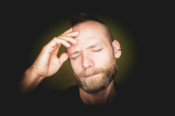 istock A middle-aged man with a headache is holding his head and eyes closed. 1277546393