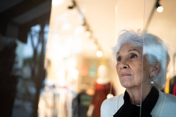 starsza kobieta patrząc przez okno sklepu - boutique store owner latin american and hispanic ethnicity zdjęcia i obrazy z banku zdjęć