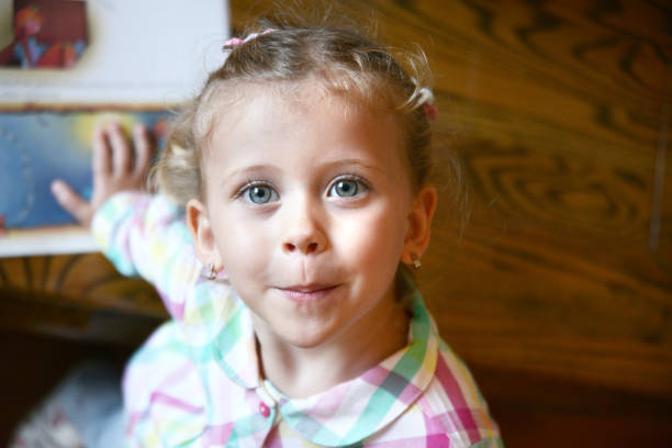 Sweet little girl in a outdoor shadowy portrait from the mouth up. Her eyes look up to the heavens. A blue, blue sky above her.