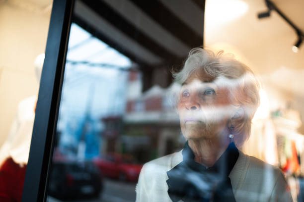 istock Senior woman looking away through store's window 1277547286