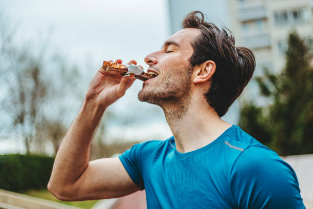 istock Man eating energy bar 1277551156
