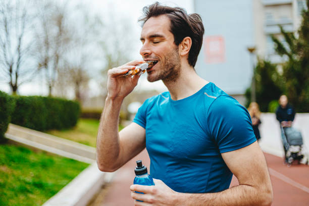 エネルギーバーを食べる男 - muscular build food healthy eating human muscle ストックフォトと画像