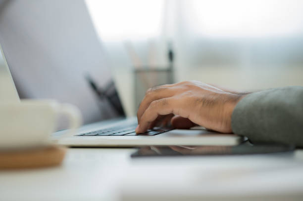 istock Close up male hands using laptop while work from home social distancing concept. Focusing Finger texting keyboard of laptop computer. 1277553078