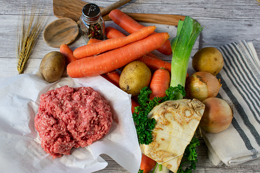 raw and uncooked minced meat with root vegetables - preparation for cooking a vegetable soup