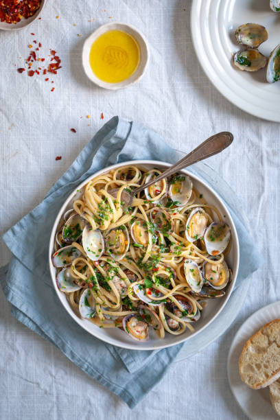 a flatlay of a bowl of pasta with clams - clam imagens e fotografias de stock