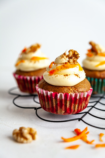 Carrot cake muffins on a cooling rack on white background