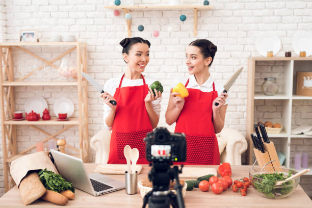 istock Two culinary bloggers hold up peppers and knives. 1277556270