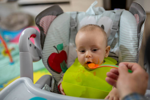 lustige niedliche entzückende baby essen in der küche - eating obsessive child toddler stock-fotos und bilder