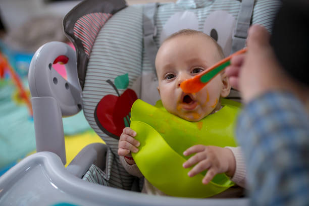 lustige niedliche entzückende baby essen in der küche - eating obsessive child toddler stock-fotos und bilder