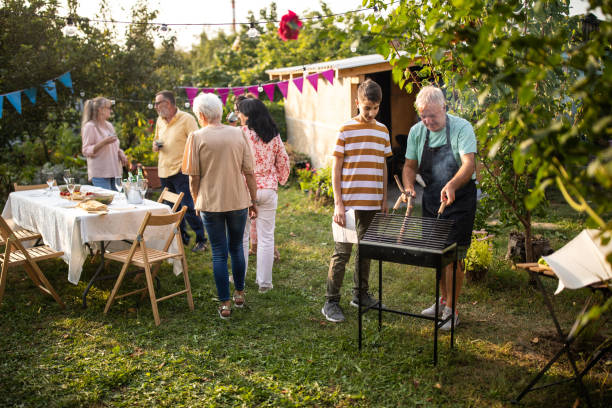 istock Grandfather teaching his grandson how to make barbeque at backyard 1277558019