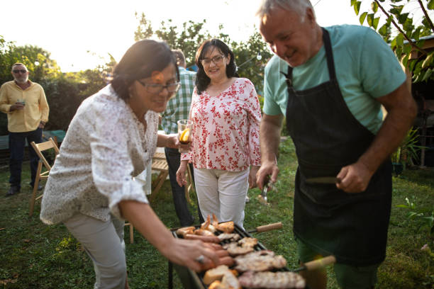istock Senior man making barbeque for his friends during party at backyard 1277558146