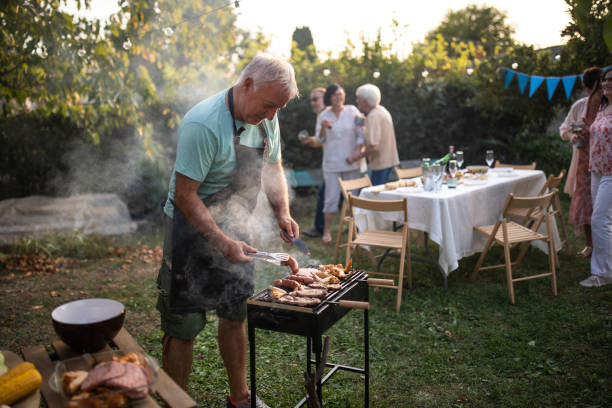 istock Senior man making barbeque for his friends during party at backyard 1277558165