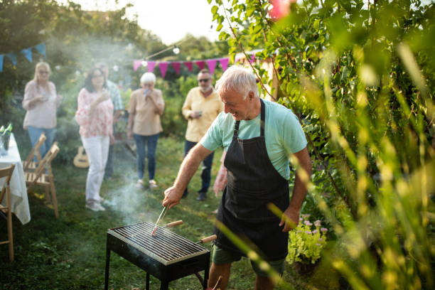 istock Senior man making barbeque for his friends during party at backyard 1277558207