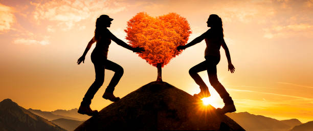 istock Composing of Two female silhouettes with a heart tree on a peak 1277560716
