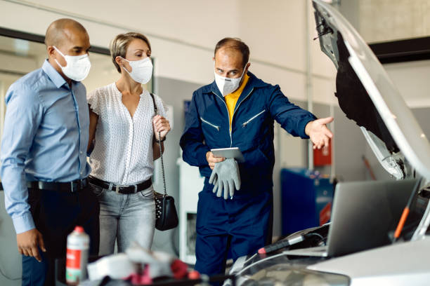 reparador de automóviles explicando los problemas del motor a los propietarios de automóviles en un taller. - auto repair shop mechanic digital tablet customer fotografías e imágenes de stock