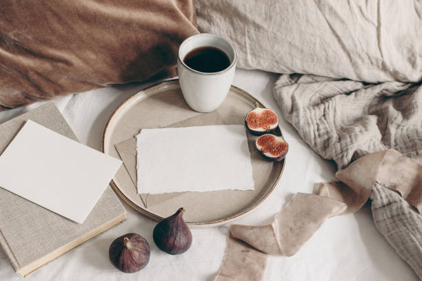 el desayuno de otoño todavía es vida. fruta de higo, libro y taza de café sobre plato de cerámica. maquetas de tarjetas de felicitación en blanco, fondo de lino. almohadas de terciopelo y lino en la cama. día de acción de gracias, concepto de otoño - velvet red center textile fotografías e imágenes de stock