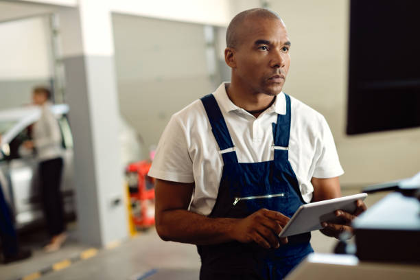 istock African American mechanic using touchpad while working on a computer at repair shop. 1277566128