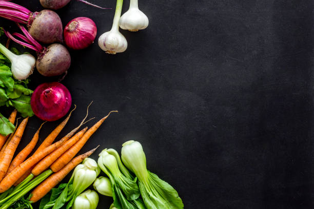 istock Flat lay of fresh vegetables and greenery on black table top-down copy space 1277566836