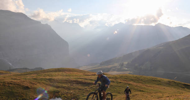 istock Mountain e-bikers ride through alpine meadow at sunrise 1277568357