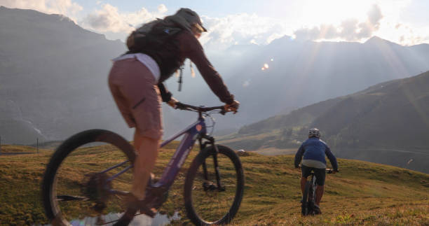 istock Mountain e-bikers ride through alpine meadow at sunrise 1277568437