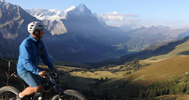 istock Mountain e-biker rides through alpine meadow at sunrise 1277568734