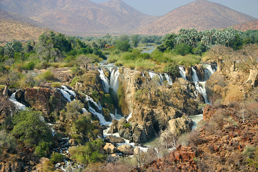 The border river between Namibia and Angola, the Kunene, plummets down a 40 metre deep gorge at the Epupa Falls close to the nearby village of Epupa. In the Herero language Epupa means “falling water”.