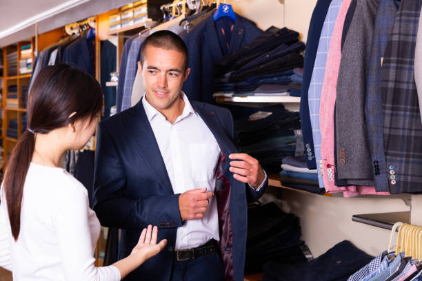 istock Smiling couple examining various suits in mens cloths store 1277577259