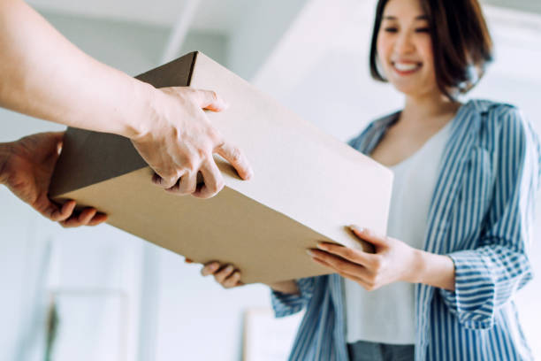 primo posto di un corriere che effettua una consegna a un cliente a casa. fornire una consegna rapida espressa direttamente nelle mani del cliente - ricevere foto e immagini stock