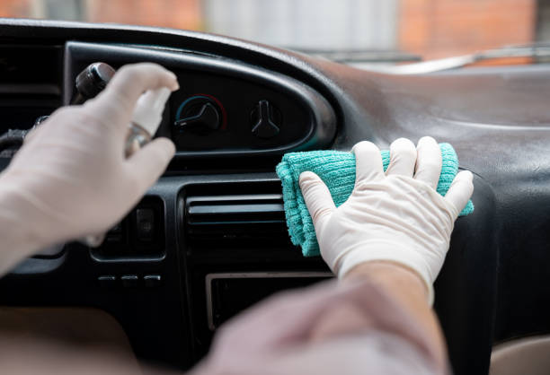 Close-up on a man disinfecting the dashboard of his car during the COVID-19 pandemic Close-up on a man disinfecting the dashboard of his car during the COVID-19 pandemic car rental covid stock pictures, royalty-free photos & images