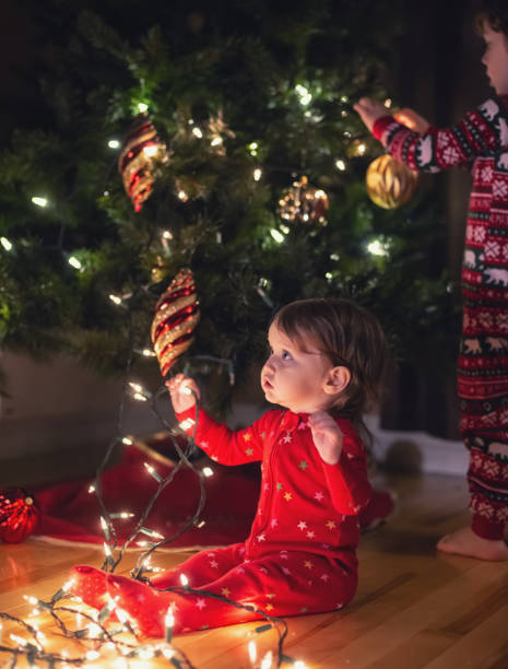 istock Brother & Sister Decorate Christmas Tree 1277582915