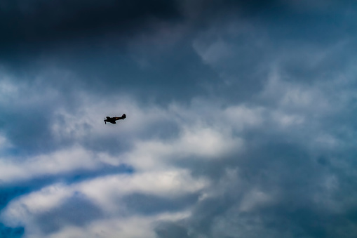 A Spitfire aircraft over Hunstanton beach, Norfolk, East Anglia, England, UK.  It is flying over holiday makers as show of support for the work of the NHS during the pandemic Covid-19 crisis.